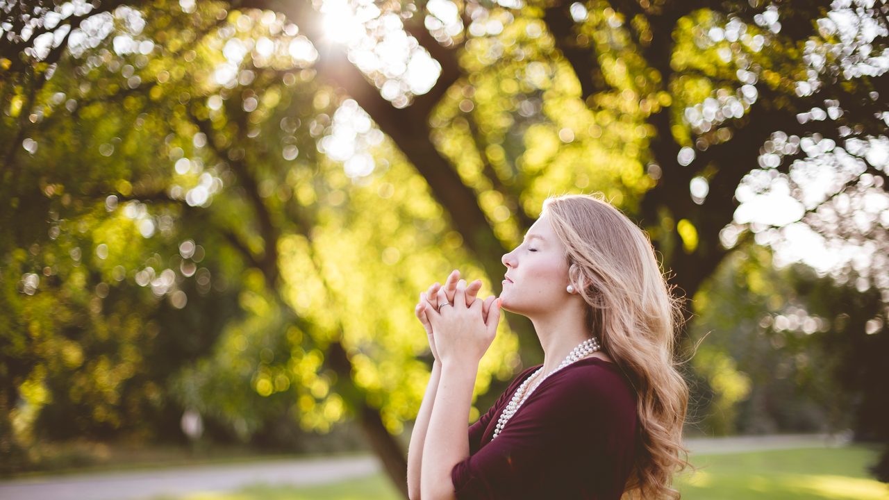 A person praying quietly outdoors